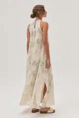 Vestido largo de red color crudo con estampado de flores, corte recto y cuello halter.