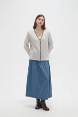 Cardigan de viscosa color marrón, con cuello en V, cierre frontal con botones y detalle de costura decorativa en contraste a lo largo de los bordes.