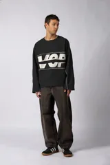 Buzo oversize de algodón rústico de alto gramaje, color negro, con diseño boxy, cortes crudos en los bordes y estampa frontal con las siglas VCP en blanco.