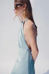 Vestido midi de satén color celeste, con cuello halter y espalda descubierta con lazada.