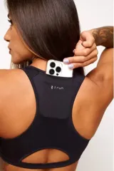 Top deportivo negro con diseño nadador, entrada para almohadillas removibles, bolsillo trasero y detalle reflectivo.