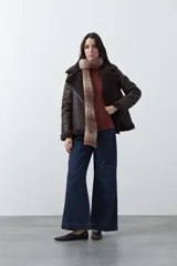 Polera de tejido liviano en color negro, con cuello alto, mangas largas y corte relajado. Presenta un diseño minimalista con recortes laterales que aportan estructura a la prenda.