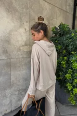 Canguro holgado color beige, con capucha y bolsillo canguro frontal.