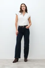 Pantalón de jean oscuro de tiro alto, corte recto y pierna ancha, con costuras verticales marcadas en el frente.