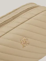 Bandolera Tommy Hilfiger color beige con diseño acolchado en diagonal y logo de la marca en dorado al frente.