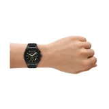 Reloj Armani Exchange modelo Sync con caja y malla de silicona negra. Esfera negra con marcadores e índices en tono dorado, función de cronógrafo y ventana de fecha.