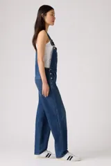 Overall de jean en color azul clásico con lavado desgastado. Presenta un diseño de corte recto y holgado, con bolsillo frontal en el pecho, tirantes ajustables con hebillas metálicas y bolsillos laterales.