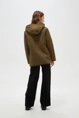 Campera de diseño capitoneado con cierre frontal, capucha integrada y bolsillos laterales. Presenta un corte entallado y mangas largas.