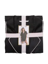 Pijama corto de satén negro con estampado monograma sutil, ribetes blancos y diseño de botones frontales.