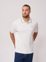 Remera polo blanca de corte regular, con cuello y mangas con ribete a cuadros en contraste. Presenta un pequeño logo bordado en el pecho.