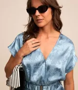 Vestido midi celeste con estampado jacquard, escote en V cruzado, manga corta y cinturón con elástico.