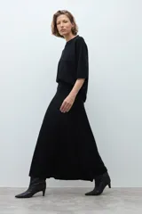 Falda midi tejida de corte recto y silueta ajustada, con cintura elástica y diseño minimalista.