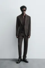 Blazer de corte regular confeccionada en tejido de lana. Presenta cuello con solapas de muesca, cierre frontal de un botón y manga larga con puños abotonados. Cuenta con bolsillos de vivo en el pecho, bolsillos con solapa en la cadera y aberturas en la parte posterior.