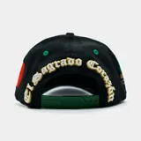 Gorra tipo trucker negra con visera verde estampada con diseño paisley en blanco. Presenta un logo bordado con la letra M en el frente y un bordado detallado de la Virgen de Guadalupe en el lateral.