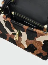 Bolso de hombro pequeño Marc Jacobs The Mini Dual Shoulder Bag, con textura de pelo animal print (leopardo/vaca) en tonos marrón, negro y beige. Presenta un cierre metálico dorado en la solapa y correa negra.