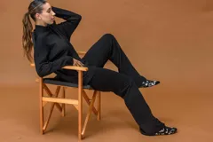 Conjunto de dos piezas compuesto por un buzo de cuello alto y pantalón de corte recto, ambos confeccionados en tejido de punto negro.