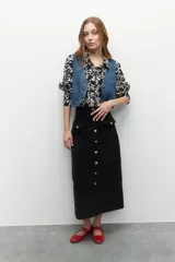 Maxifalda color borgoña de pana con botones metálicos al frente y cuatro bolsillos, dos de ellos con solapa.