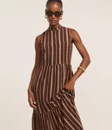 Vestido midi evasé sin mangas, confeccionado en viscosa, con cuello alto, corte en la cintura, recortes fruncidos en la pollera y rayas verticales desencontradas.