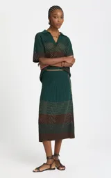 Pollera midi de punto con diseño calado, en combinación de colores verde y marrón, de corte recto y tiro alto.