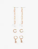 Set de aros dorados con diferentes diseños: aros colgantes con cadena y dije de perla, aros tipo cuff con strass y aros tipo argolla con dije de gota con strass.