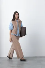 Pantalón de pana de corte wide leg, color marrón oscuro, con calce relajado y detalle de bordado en el borde de los bolsillos delanteros.