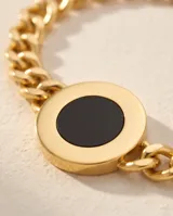 Pulsera de cadena de eslabones con baño de oro y dije circular central con piedra ónix negra.