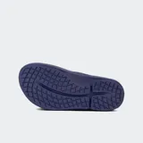 Sandalias tipo ojota de recuperación OOFOS, color negro, con diseño ergonómico de plataforma y tecnología OOfoam para mayor absorción de impacto y soporte del arco plantar.