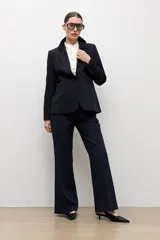 Blazer clásico color negro de corte entallado, con solapa de muesca, cierre de un botón frontal y bolsillos de ojal en los laterales.