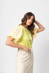 Blusa verde con cuello redondo y mangas cortas abullonadas.