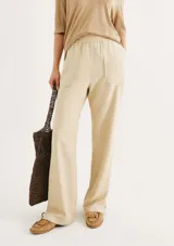 Pantalón color marrón, de corte carrot y cintura alta con elástico.