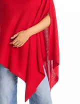 Poncho tejido de punto con diseño asimétrico y aberturas laterales para los brazos.