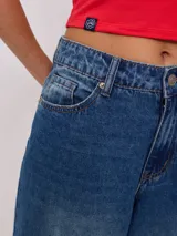 Jean de corte wide leg con tiro medio, confeccionado en denim de algodón en tono azul medio con efecto lavado.