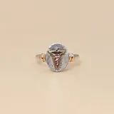 Anillo de diseño ovalado con emblema de caduceo médico en relieve, elaborado en una combinación de plata y oro.