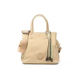Cartera tipo tote de tamaño pequeño en color beige, confeccionada en material textil. Cuenta con doble asa de mano, correa de hombro ajustable y extraíble, y un detalle decorativo de borlas de cordón en la parte frontal. Incluye un aplique circular con el logo de la marca en el centro.