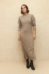 Vestido largo de punto color gris, con cuello alto, mangas largas y aberturas laterales en el ruedo.