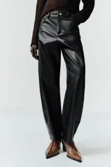Pantalón de tiro medio con diseño tipo ballon, confeccionado en material efecto piel. Cuenta con cinco bolsillos, cierre frontal con cremallera y botón metálico.