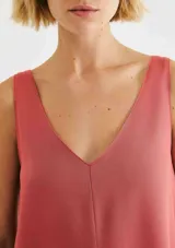 Vestido corto sin mangas de color rosado, con silueta recta y escote en V pronunciado.