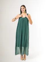 Vestido largo de seda italiana en color verde inglés, con tirantes anchos, escote redondo y diseño holgado con frunces. Cuenta con forro interior de viscosa elastizada.