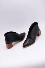 Botines de cuero color beige con diseño de tajo frontal, punta fina y taco cuadrado de madera.