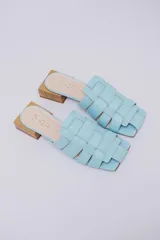 Mules de cuero celeste con diseño trenzado y taco de madera.