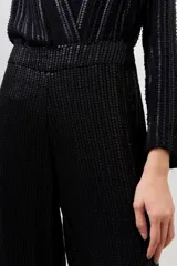 Pantalón de corte palazzo color negro, íntegramente bordado con lentejuelas y mostacillas. Presenta tiro medio, largo al piso y cierre invisible en el lateral.