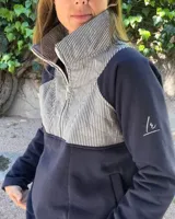 Buzo de algodón combinado en azul marino, con cuello alto, medio cierre frontal y un panel superior capitoneado con diseño a rayas.