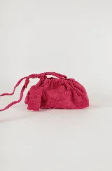 Cartera tipo sobre de cuero color fucsia, con diseño fruncido y cierre de cordón. Incluye una correa ajustable y extraíble para usarla como cartera o como sobre de fiesta.