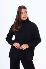 Buzo tejido de punto color negro, con cuello alto, manga larga y corte holgado con aberturas laterales en el ruedo.