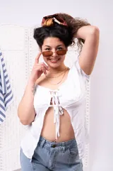Blusa blanca de manga corta abullonada, con escote corazón y cierre frontal con múltiples lazos para atar.