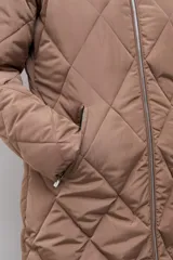 Campera acolchada de corte largo con diseño capitoneado en forma de rombos, cierre frontal con cremallera y capucha integrada.