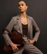 Blazer slim de punto roma color marrón con cuello solapa, abotonado delantero de botón doble forrado, bolsillos tipo cuchillo y manga larga.