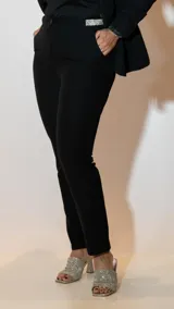 Pantalón de vestir negro de corte recto y tiro medio, confeccionado en tela sastrera con acabado liso.