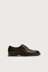 Zapato de vestir tipo derby marrón oscuro, con parte superior lisa y suela con ligero tacón.