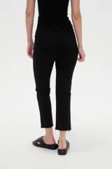 Pantalón jean de tiro alto y corte recto, color blanco, con bolsillos laterales y traseros, y terminación desmechada en los tobillos.